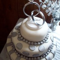 White And Silver Engagement Cake This cake was for an engagement party. It was all covered in white fondant with the bottom tier being pound cake, the middle tier chocolate...