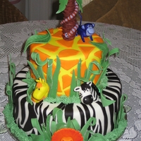 Baby Animal Jungle Cake 6 & 8" tier of Chocolate Cake with Chocolate Mousse. Covered in Fondant. All accent pieces & Animals made of Fondant. TFL