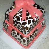 Animal Print Cake Two tier animal print gift box cake. Base is chocolate cake with strawberry icing, and the top is chocolate cake filled with coconut.