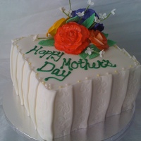 Mother's Day Floral White cake with coconut buttercream filling. Gumpaste roses are airbrushed then handpainted with highlights. Pleating around the cake is...