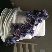 Floral Wedding Cake Wedding cake for client who wanted all roses in shades of purple and all white cake. Covered in fondant, gumpaste and dusted flowers.