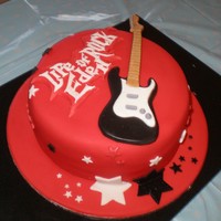 Rock Guitar Birthday Cake Sugar paste guitar, used Trex to give it a sheen. Lettering done as runouts with glitter to cover over the non perfect bit. Cake covered in...