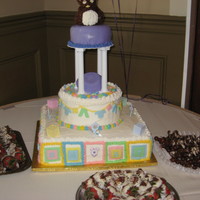 Baby Shower Cake W/ Teddy & Baby Clothes Tier Cake w/ square tier of baby blocks,next tier baby clothes, Purple tier w/teddy bear ,in middle of tiers is an umbrella (purple was the...