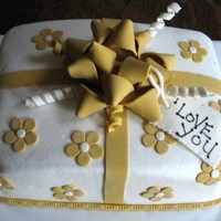 Gift Cake Hi there,This cake is covered with buttercream icing and then all the accents and bow are made with fondant. Thank you for looking.