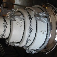 My First Official Wedding Cake. The bride asked that her 4 tier wedding cake have sprays of silver calla lillies and black scrolling on it, so this is what I came up with...