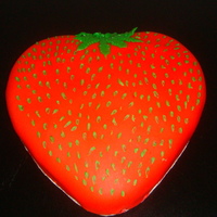 Strawberry Cake strawberry flavored cake covered in red fondant with butter cream seeds.