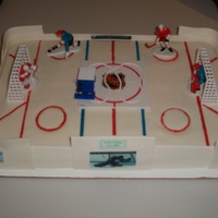 Hockey Groom's Cake Hockey cake is lemon with chocolate icing covered with fondant. The walls are gumpaste. The Zamboni machine moves on the track in the...