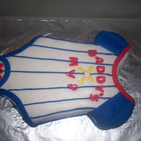 Baseball Onesie Carved chocolate cake filled with chocolate peanut butter buttercream.It is covered in Michelle Foster's fondant. I was told the...