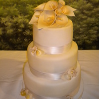 Calla Lilly My very first wedding cake. lemon cake with raspberry filling. Gumpaste flowers, fondant and ribbon