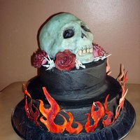Skull Cake The skull is crispy treats covered in fondant. the cake is covered in buttercream and the flames are gumpaste hand cut and painted.