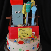 Handy Manny Birthday Cake Raspberry swirl cake with white chocolate raspberry mousse filling. All the tools are made from gumpaste. Toolbox is covered in white...