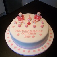 Two Little Girls Christening Cake i made this for a double christening.The cake is a 10" cake iced with white sugarpaste.The fairies are made of modelling paste