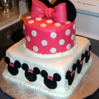 Minnie Mouse Cake Iced in buttercream with fondant minnie mouse, bow, and ears.