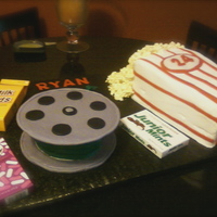 Movies & Popcorn Movie reel 8-inch cake with top and bottom cut out of gumpaste. Popcorn 9x13 cut, stacked and carved with fondant accents and real popcorn...