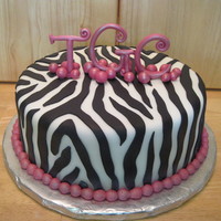 Zebra Stripes Cake is covered with and stripes are made of marshmallow fondant. The initials are gumpaste.