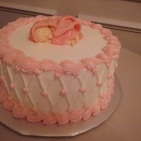 Sugar And Spice Fondant baby sleeps on top of this buttercream covered cake