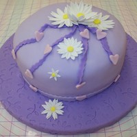 Purple Innocence Purple fondant and gumpaste cake, daisies, hearts and swirl ribbon Completed Wilton fondant and gumpaste class, personal creation