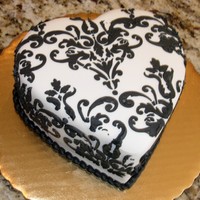 Black And White Mini Damask Heart A small 5" heart cake covered in white chocolate fondant and a black royal icing stenciled damask pattern.