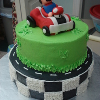 Mario Cake Vanilla Cake with BC. The car is Rice Crispy Treat covered with fondant and MMF as well as Mario.