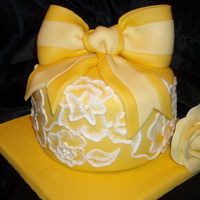 Yellow Spring Cake 6 inch cakes covered in white chocolate marshmellow fondant. Flowers around the sides of the cake through brush embroidery. Fondant bow and...