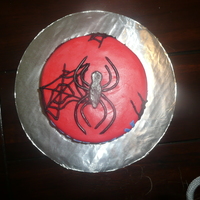 Spiderman Birthday Small round cake covered in red MMF with black MMF spider, blue MMF "Spiderman" and black buttercream spider webs.