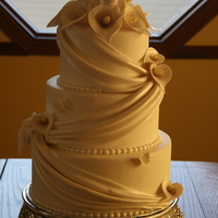 Draped Round White fondant with white drape. Drapes pearled to look like satin. Calla's have a blush of lavender in their throats to break up the...
