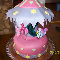 Merry-Go-Round Merry-go-round. round cake covered with MMF. Used sticks (that was covered) for the poles. The mother of the girl gave me the ponies.......