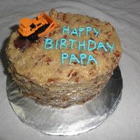 German Chocolate Bulldozer German chocolate cake with the traditional pecan-coconut frosting. Letters piped in BC. Toy bulldozer added to the top.