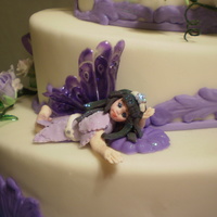 Purple Fairy Fondant cake, gumpaste flowers and fairies, gelatine wings and leaves and ribbons.