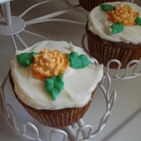 Carrot Cake Cupcakes Carrot cake cupcakes topped with maple cream cheese icing and a royal icing mum