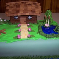 Cabin Home Log cabin home made from rice crispy treat. Cabin covered with fondant. Flowers made from fondant. Pond is made from gel.