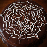 Chocolate Ganache Spider Web Cake Chocolate cake with raspberry sauce soaked into the layers. Vanilla custard filling and ganache over the top. White chocolate was used to...