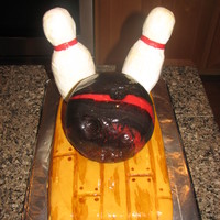 Bowling Cake This was my 4 year old's bowling birthday cake. The alley and the ball are both cake covered with fondant. I painted on the wood grain...