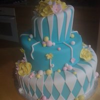 Lindy This suess inspired cake is covered in turquoise fondant and decorated with white, yellow and pink pastels. Free-formed yellow flowers...