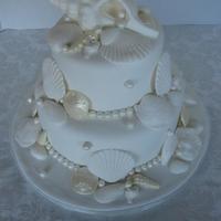Shell Wedding All white Sea shell wedding cake. Shells are fondant, sand dollars are chocolate.