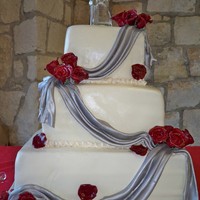 Silver Draped Cake this was is a butter cake with pineaplle filling. The flowers are handmade out of gumpaste and the drapes are fondant.