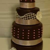 Ganache Goodness Chocolate cake with oreo buttercream and chocolate ganache. Pink ribbon is wrapped around the bottom of each tier. The flowers on top are...