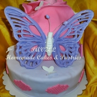 Butterflies And A Rose A 2-tiered cake with the top layer shaped and decorated to resemble a rose then decorated with a bunch of butterflies in all shapes and...