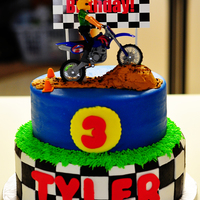 3Rd Birthday Dirtbike Cake White cake with buttercream covered with MMF. MMF accents. The only thing not edible is the dirt bike and the "billboard" sign....