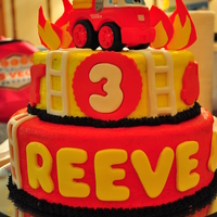 Reeve's 3Rd Birthday Cake Firefighter theme cake. It had red firetruck cut outs on the top tier and yellow fire hats around the bottom tier.