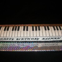 Piano Keyboard Cake Made with two 9x13 cakes, trimmed and cut down the middle, two layers. Fondant and gumpaste.