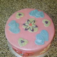 Flower Power/hearts 6" vanilla sponge filled with buttercream and jam. All decoration is in fondant, sprayed with a lustre.