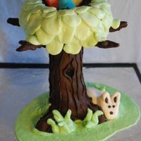 Easter Magic Tree Cake A chocolate-orange cake (cupcakes for trunk, round cake for top) covered in modeling chocolate with MMF decorations.