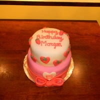 Strawberry Birthday Cake Two tiered cake covered in fondant for a Strawberry shortcake themed birthday party. Bow is made of mixture of gumpaste and fondant.