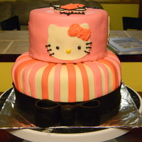 Hello Kitty Birthday Cake Two Tiered covered in fondant. Decorations are also fondant, the bow is a mixture of fondant and gumpaste. The Hello Kitty faces were cut...