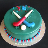 Field Hockey Cake Chocolate with chocolate butter. Covered in rolled fondant and decorated with handmade fondant hockey sticks and ball.