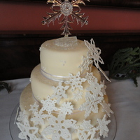 Snowflake Wedding Cake a basic white almond wedding cake with blackberry filling. 12", 9" and 6". Covered in mmf and Snowflakes are gumpaste. The...