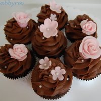 Chocolate Cupcakes With Pink Flowers Chocolate with chocolate buttercream. Sugar pearls. Pink fondant flowers.
