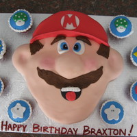 Mario Brothers Sculpted Mario and matching cupcakes. Fondant covered and details.