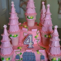 Castle Cake Vanilla cake covered in buttercream. Towers are candy coated ice cream cones, and the "shingles" for the towers are fondant...